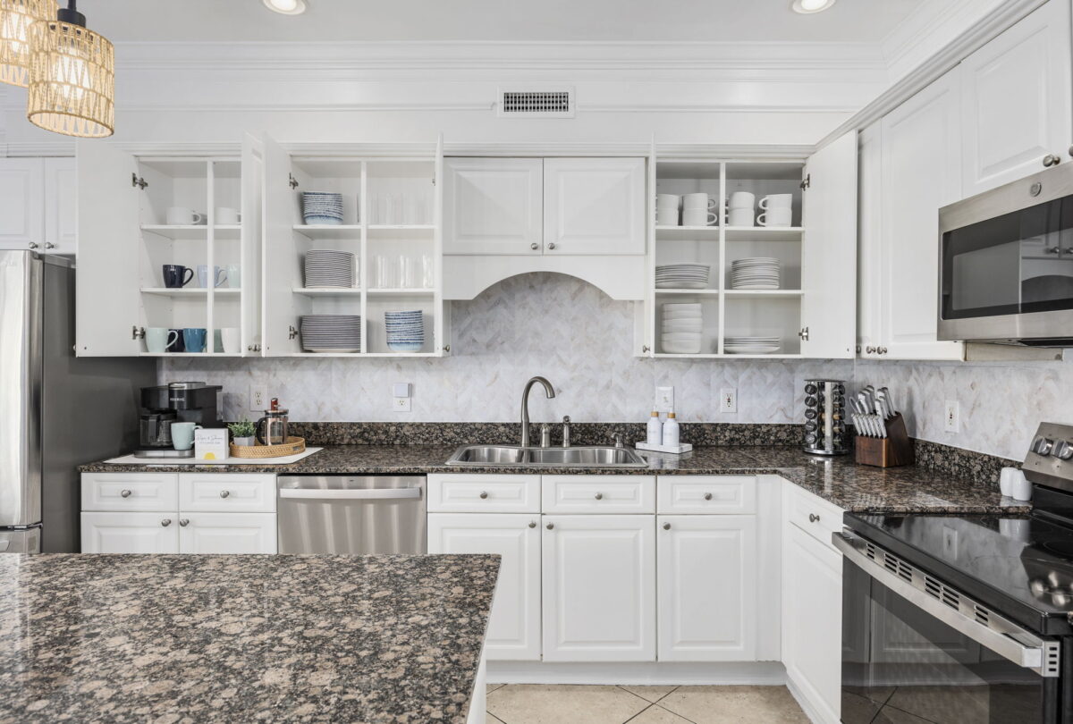 White kitchen with granite worktops and glass-fronted cabinets