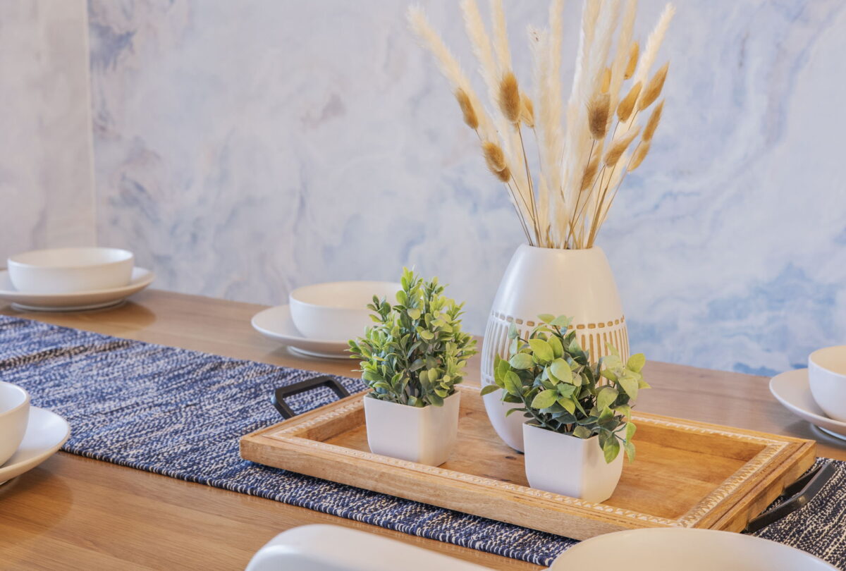 Dried pampas in a ceramic vase on a styled wooden tray