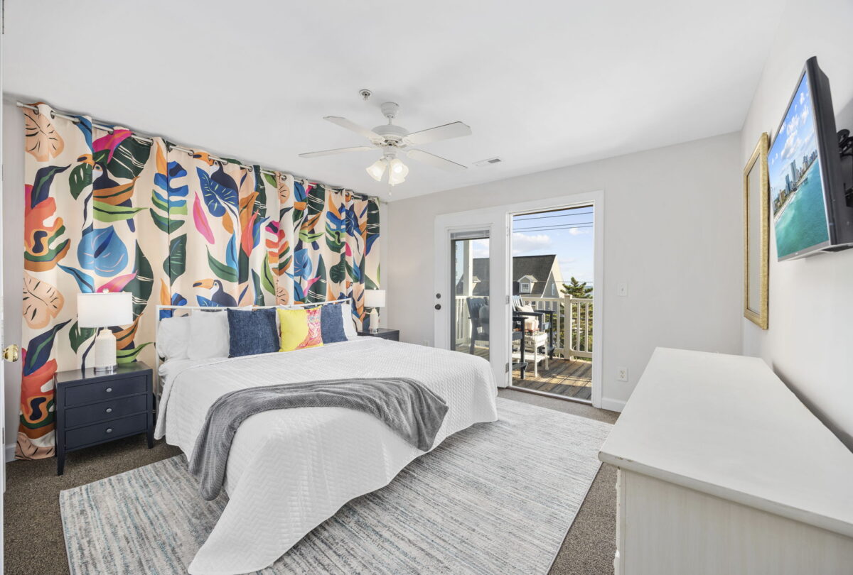 Bedroom with a botanical feature wall and a door to the balcony