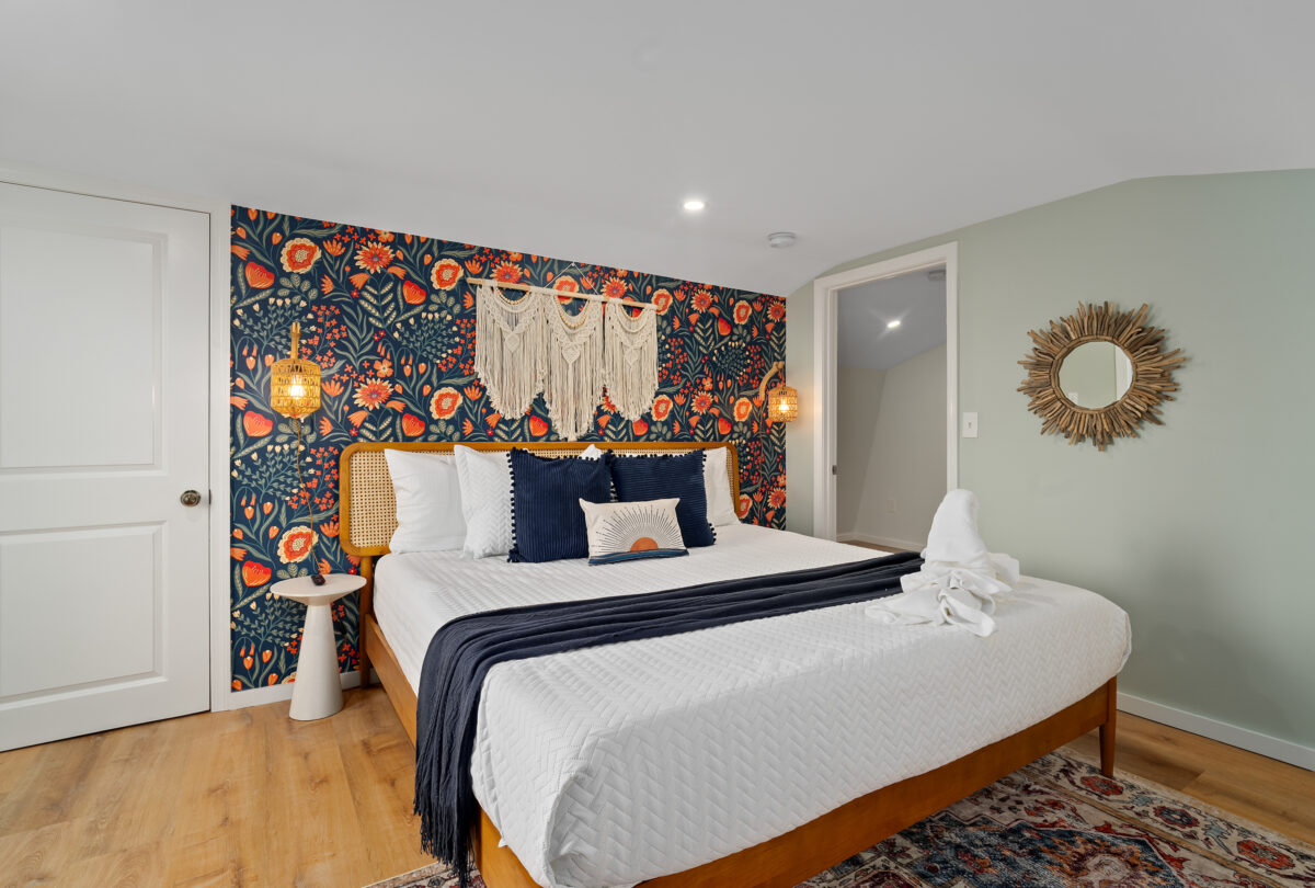 Bedroom with folk-floral wallpaper and a macrame wall hanging