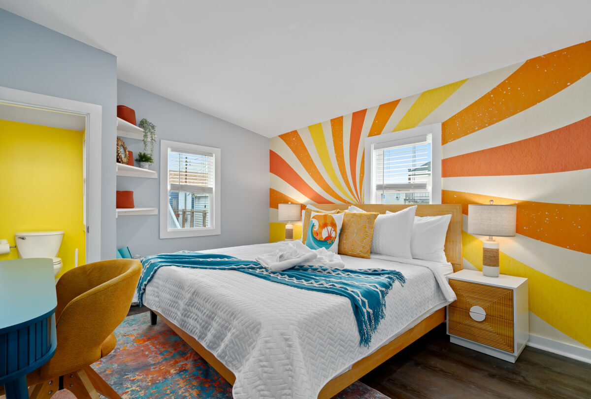 Bedroom with a sunburst mural in orange and yellow