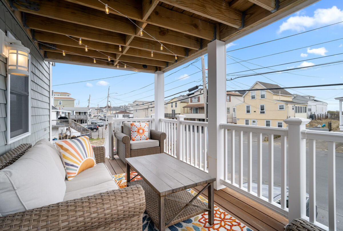 Covered porch with wicker armchairs and a patterned outdoor rug