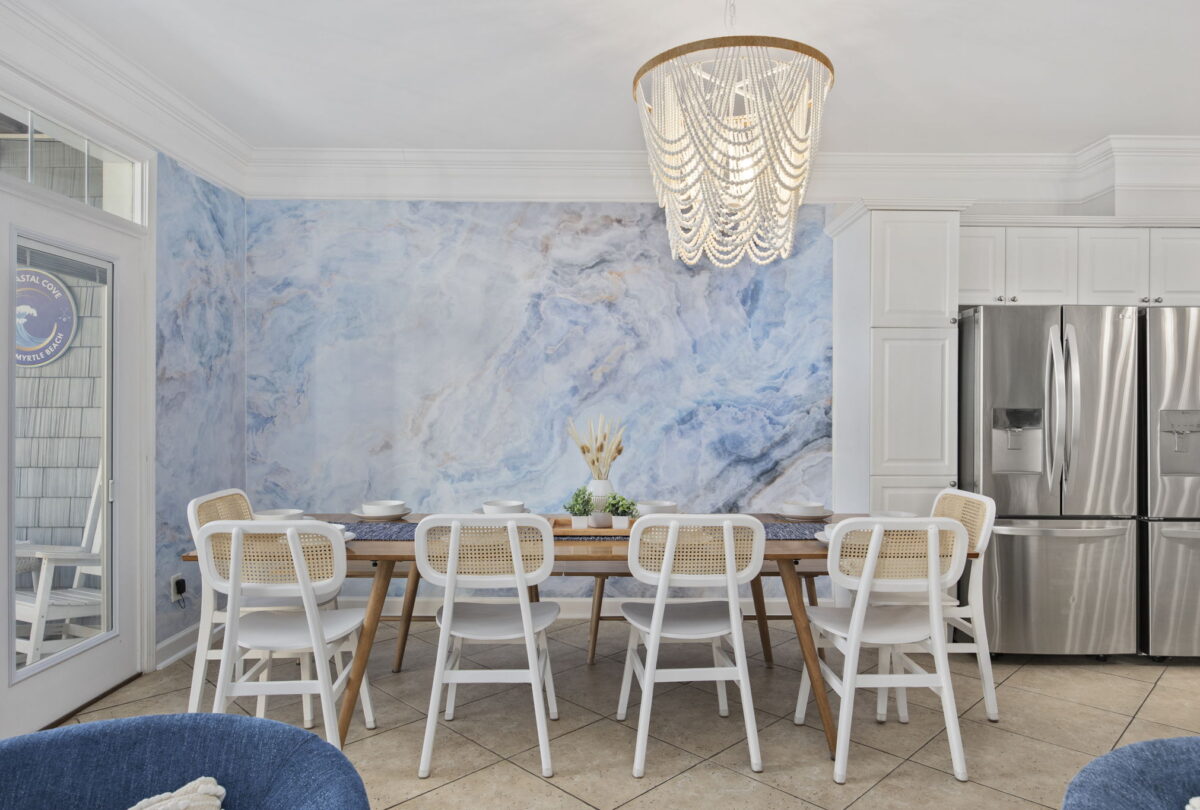 Dining room with white chairs against a blue marbled feature wall