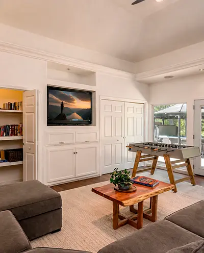 Living room with a built-in television, bookshelves and a foosball table