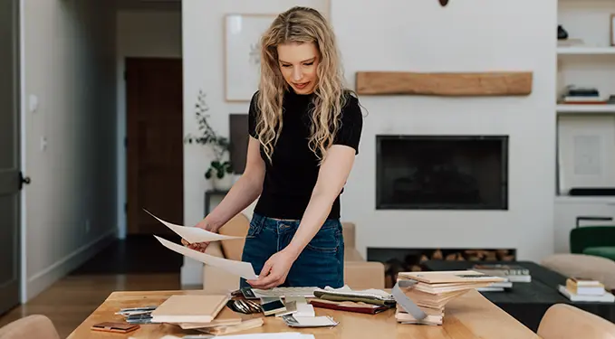 Designer laying out fabric and paint samples beside a fireplace