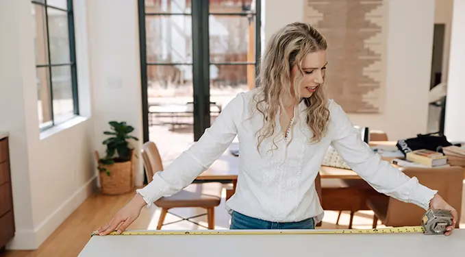 Designer arranging material samples on a table in a bright room