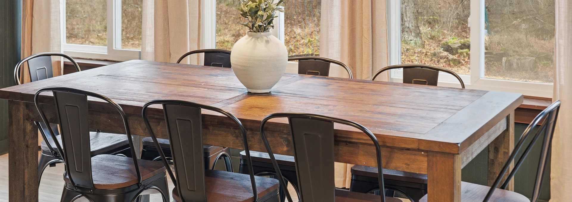Ceramic vase on a timber dining table with metal chairs