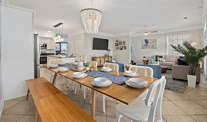 Dining table set for eight beneath a beaded chandelier
