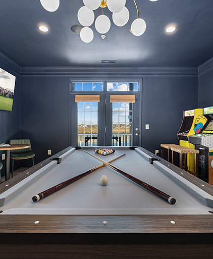 Games room with a pool table and arcade cabinet under a navy ceiling