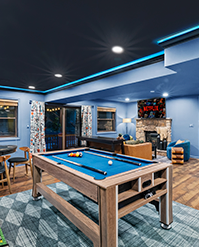 Games room with a pool table, stone fireplace and blue LED lighting