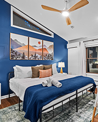 Bedroom with a cobalt accent wall and framed mountain prints