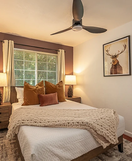 Bedroom with a knitted throw, deer print and warm bedside lamps