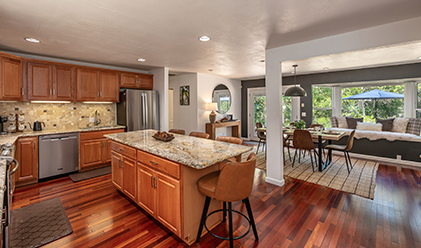 Open-plan kitchen with a granite island and timber floors