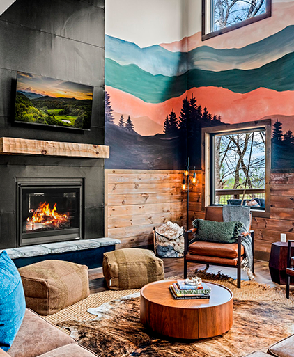 Lounge with a lit fireplace, mountain mural and timber panelling