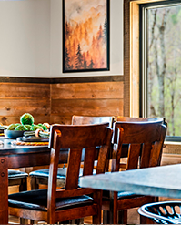 Dining area with timber panelling and a landscape painting