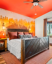 Bedroom with a forest mural and a chevron timber bed frame