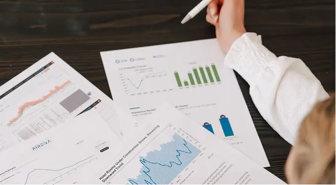 Hands reviewing performance charts and revenue reports