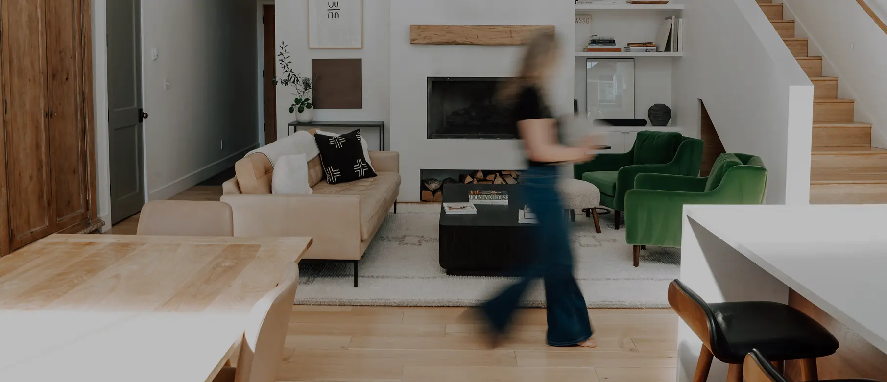 Living room with a cream sofa, fireplace and a person walking past