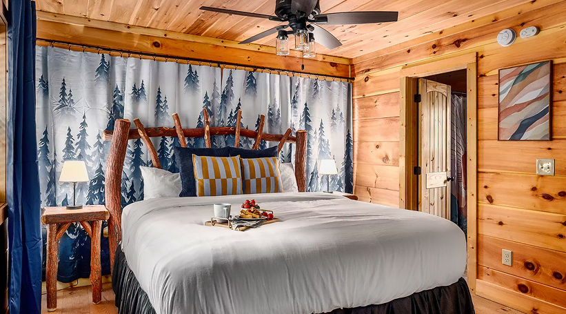 Bedroom with a log headboard, forest curtains and a timber ceiling
