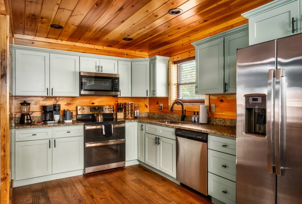 Kitchen with sage green cabinets and stainless appliances