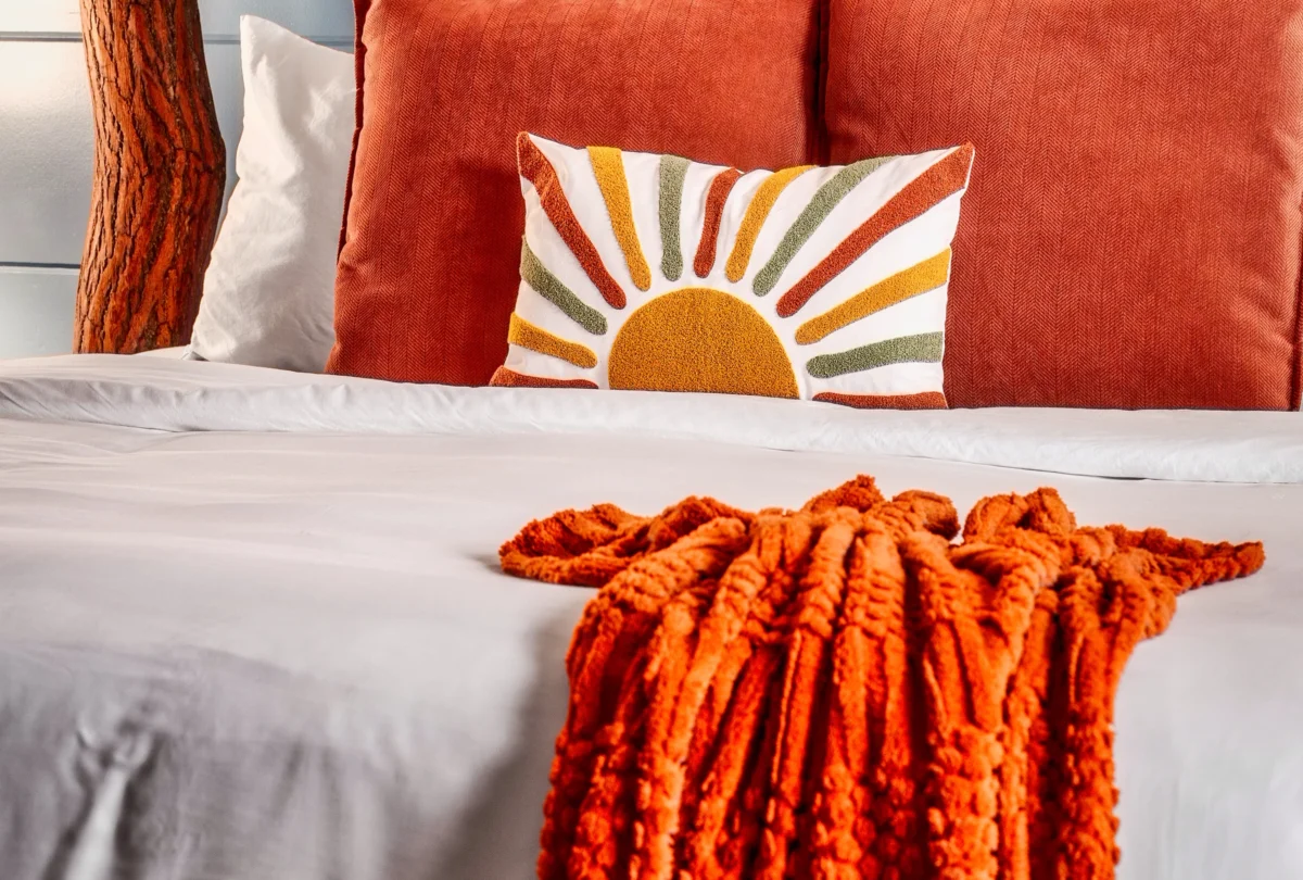 Bedroom with a branch headboard and a sunburst cushion