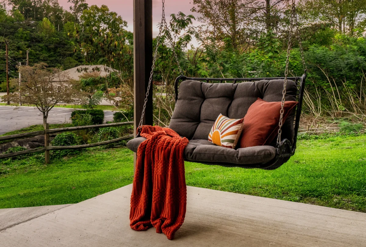 Porch swing with a rust throw at dusk