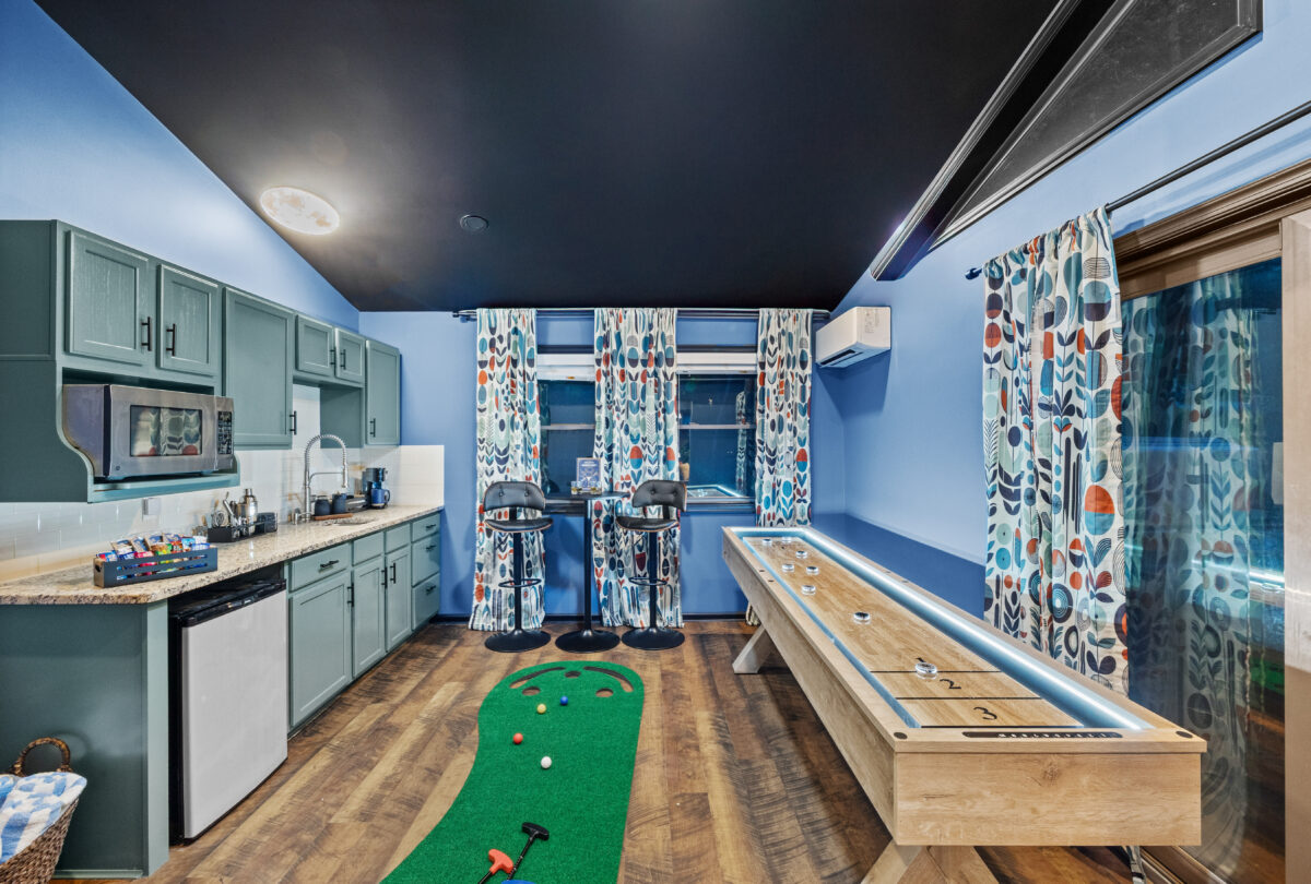 Games room with an indoor putting green and blue cabinetry