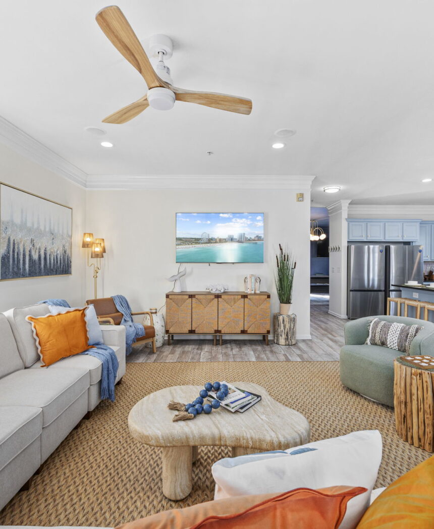 Open-plan living room with a cream sectional and a view through to the kitchen