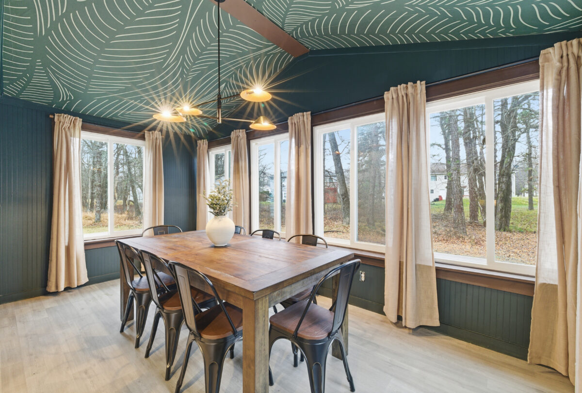 Dining room with a teal patterned ceiling and a long timber table