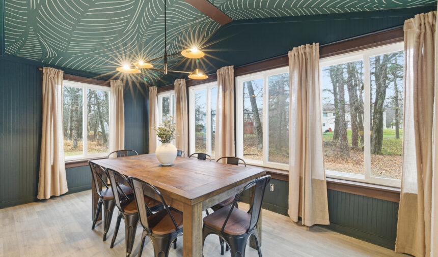 Dining room with a teal patterned ceiling and a long timber table