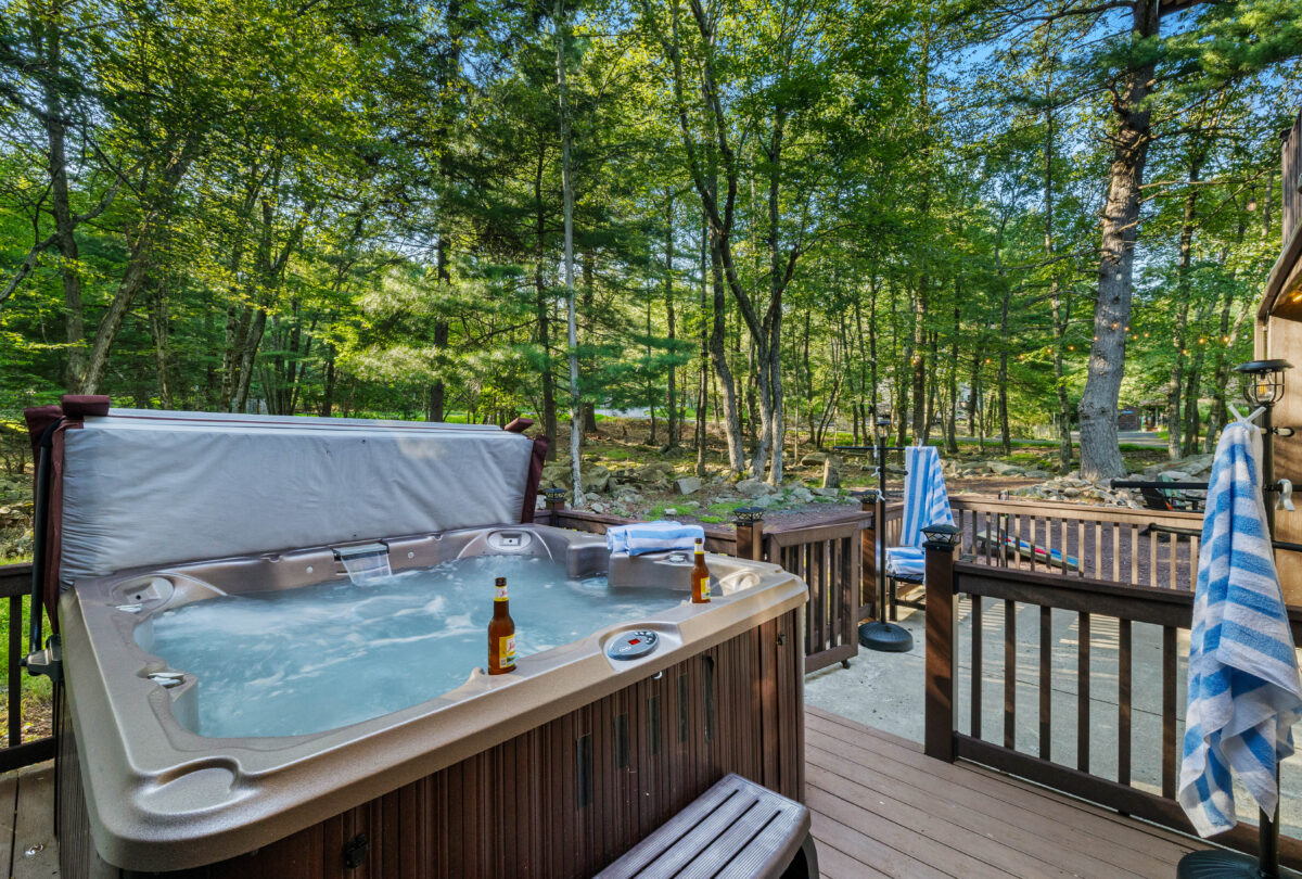 Outdoor hot tub on a timber deck surrounded by woodland