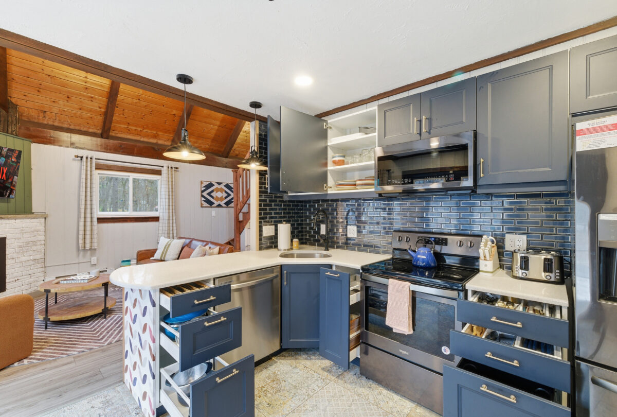 Kitchen with grey cabinetry, a blue tiled splashback and a timber ceiling