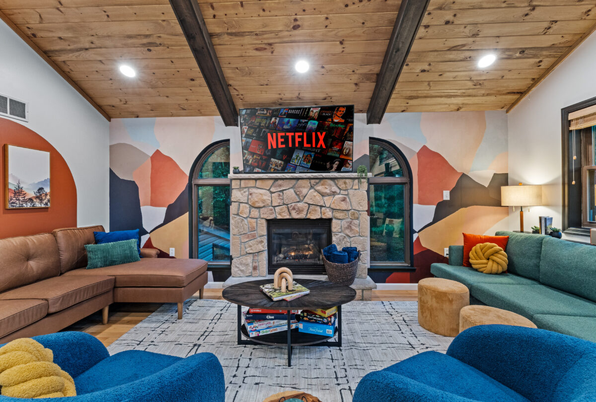 Lounge with a stone fireplace, mountain mural and blue armchairs