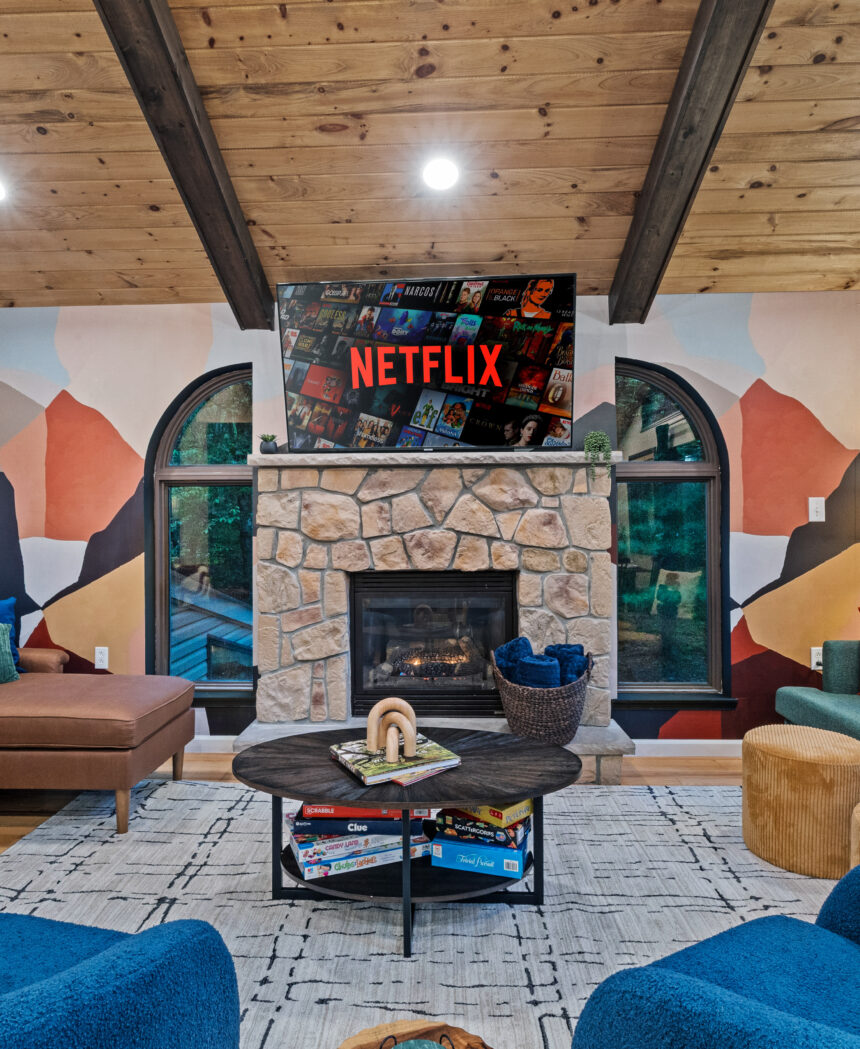 Lounge with a stone fireplace, mountain mural and blue armchairs