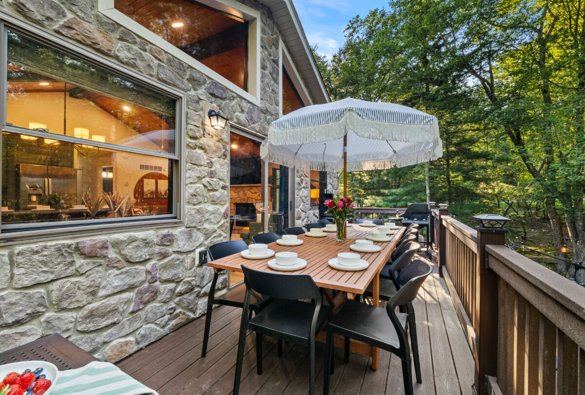 Stone patio dining table set for eight under a white parasol