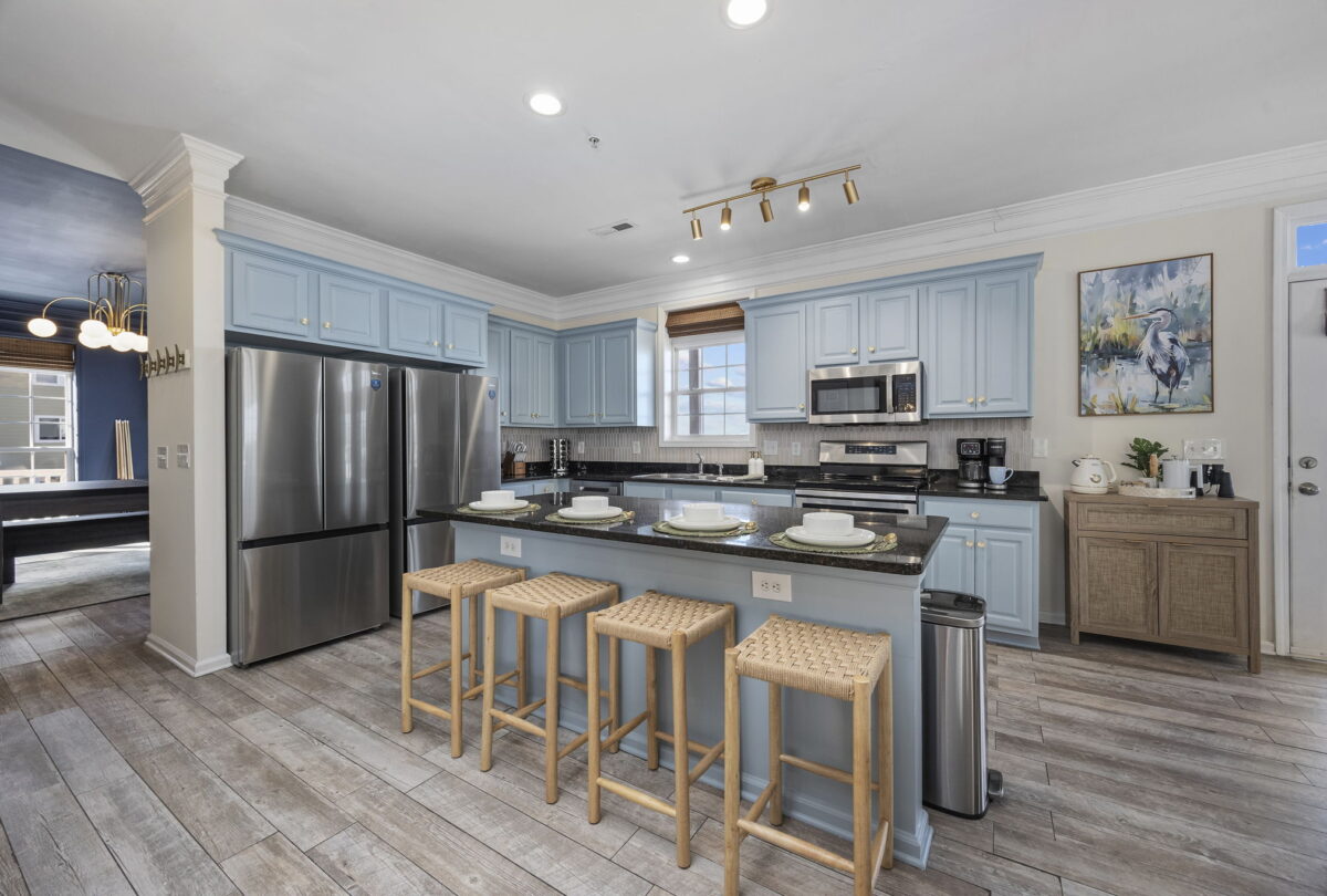 Kitchen with pale blue cabinetry, a breakfast bar and woven stools