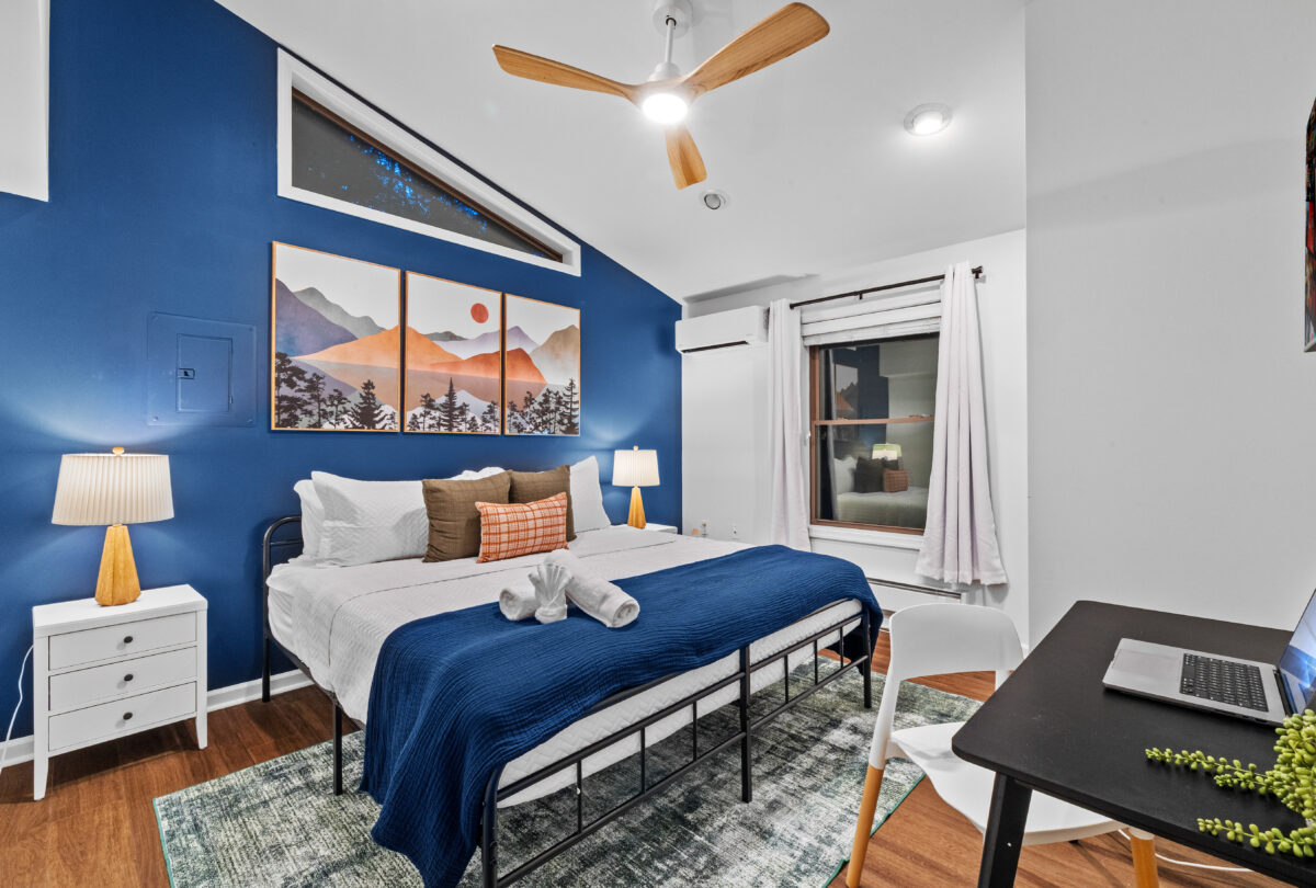 Bedroom with a blue accent wall and framed mountain prints