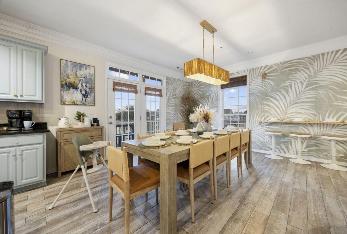 Dining room with a long table, botanical wallpaper and a linear pendant