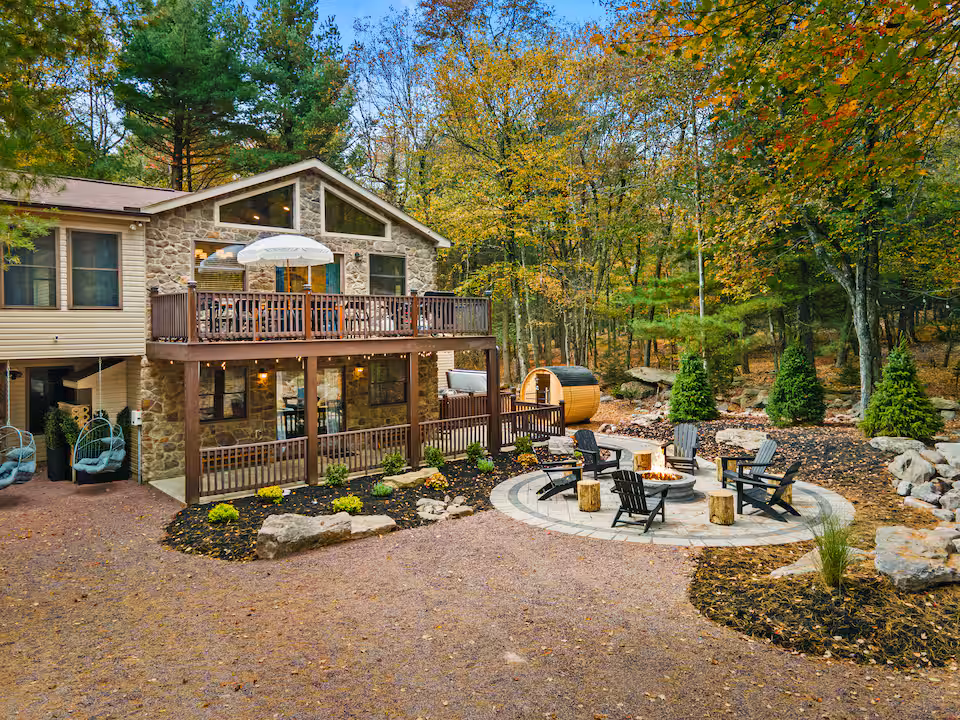Timber lodge with a deck above a landscaped fire pit area