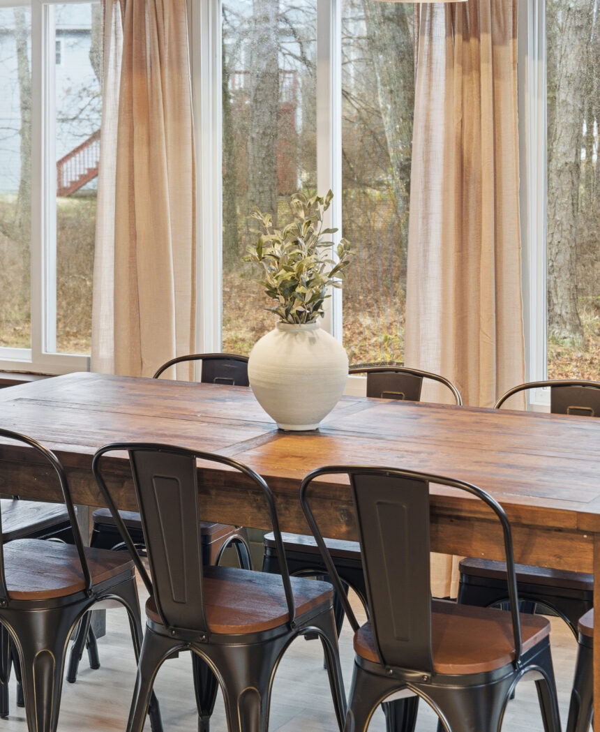 Dining room with a timber table and metal chairs beside tall windows