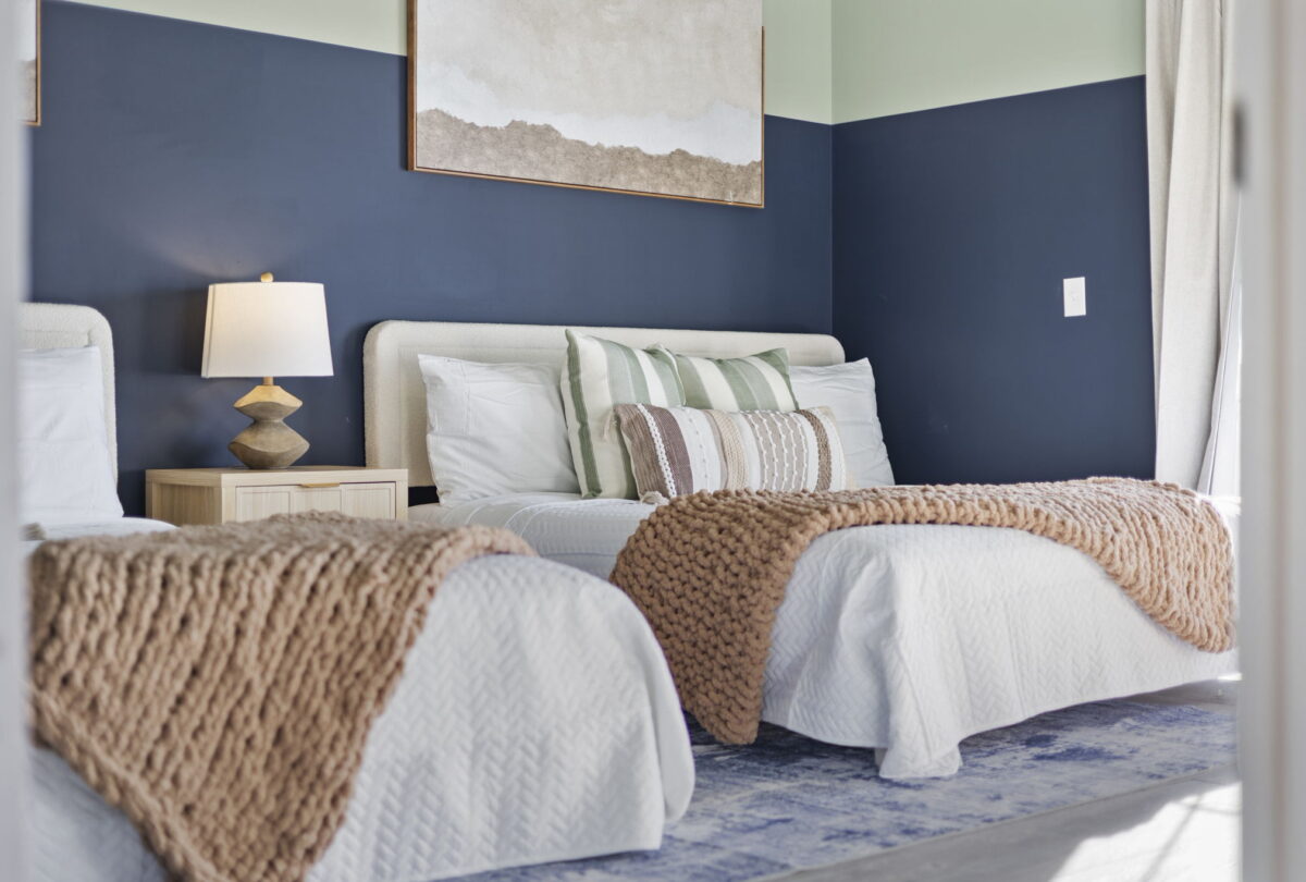Bedroom with navy and white walls and layered knitted throws