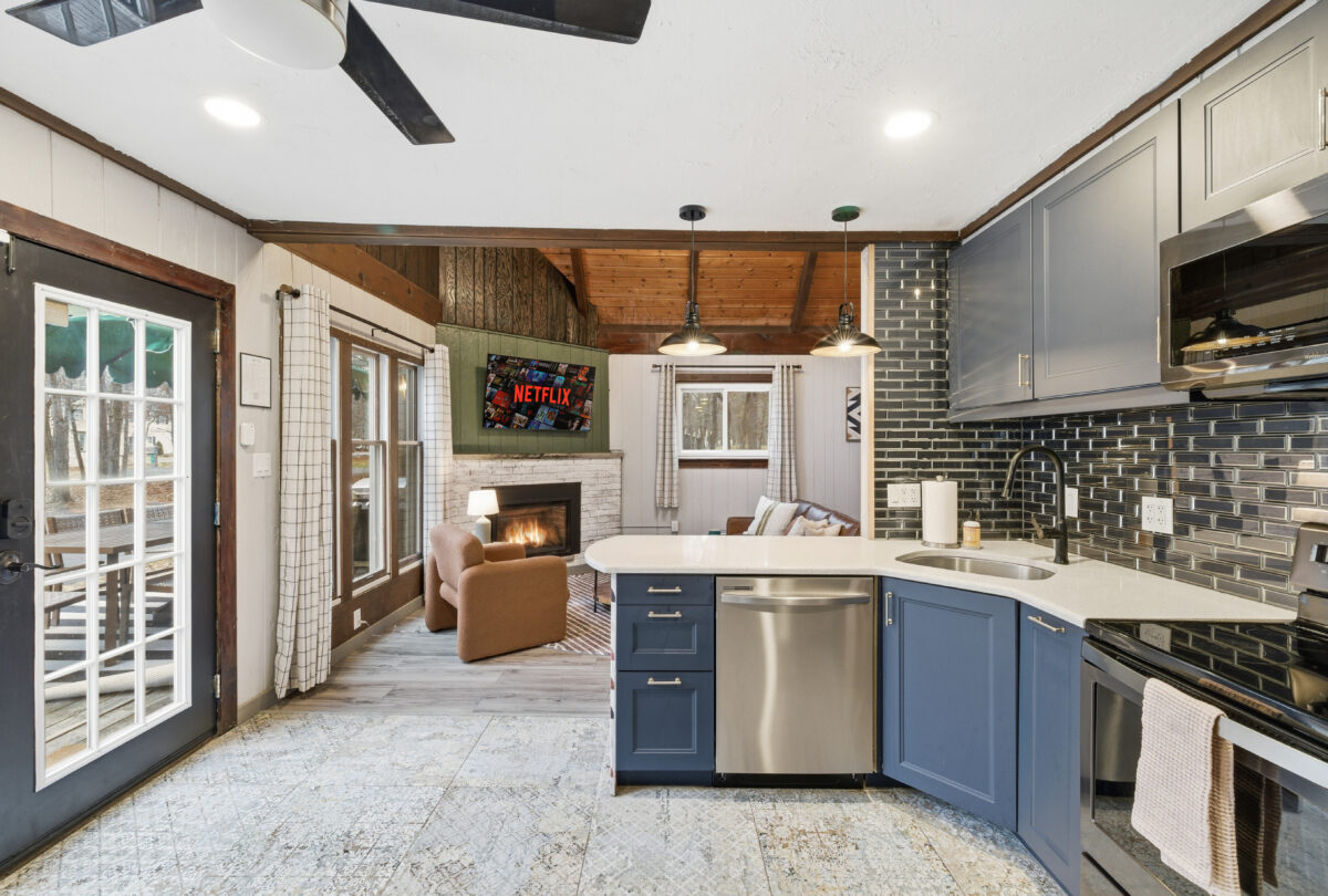 Open-plan kitchen with blue cabinetry and a view through to the fireplace
