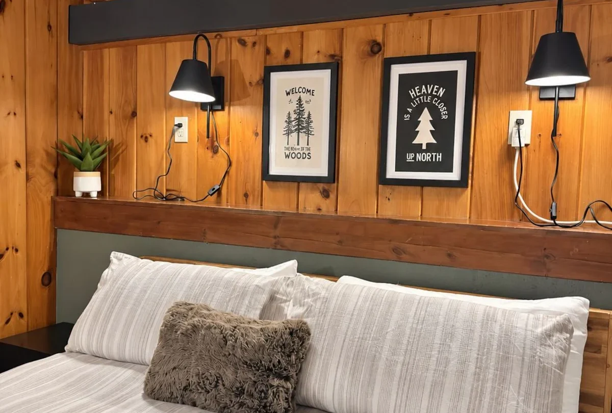 Bedroom with wall lamps and framed prints over the headboard