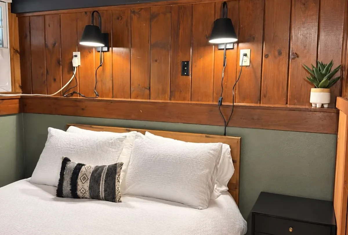 Bedroom under the pitched ceiling with a sage green wall