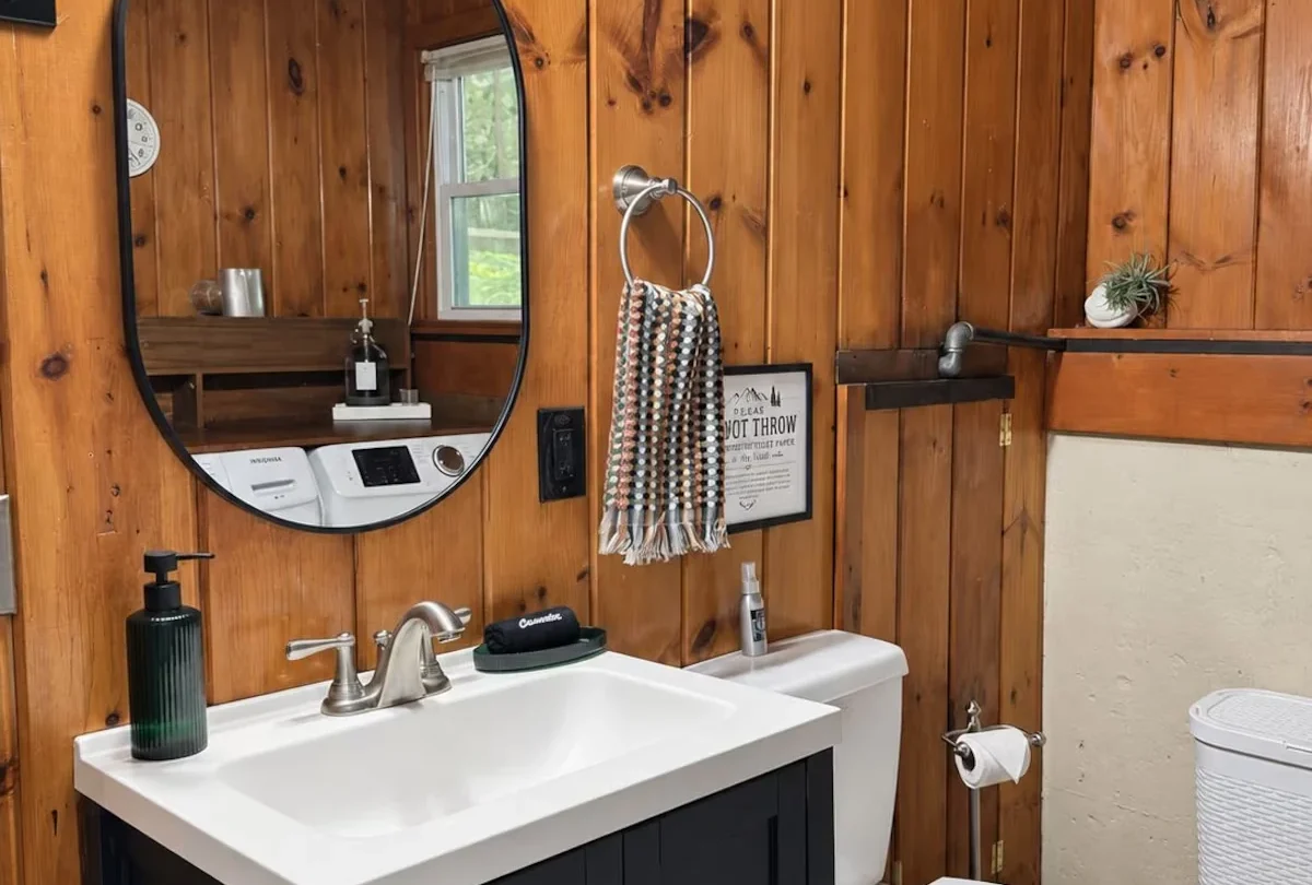 Bathroom with a round mirror and a timber vanity