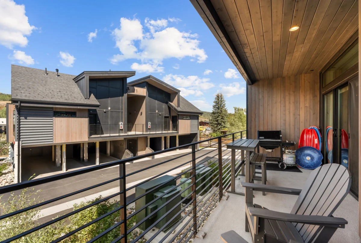 Deck with a grill and Adirondack chairs above the valley