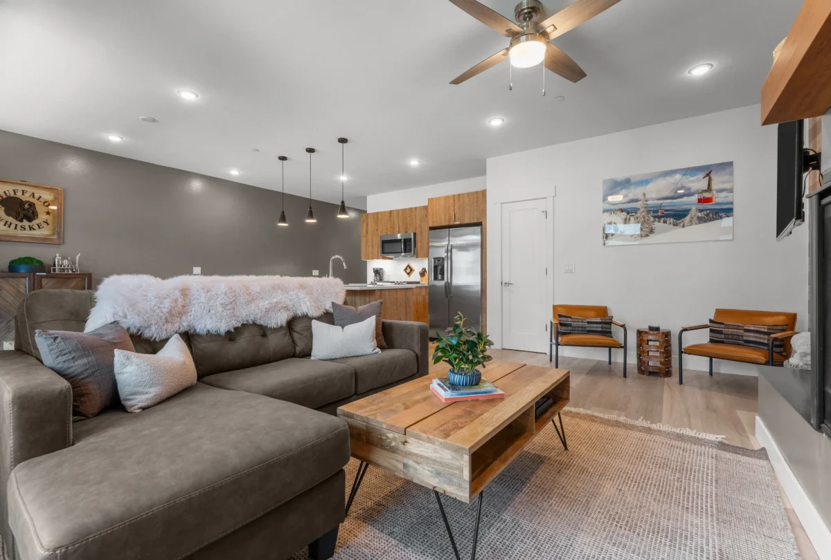 Living room with a grey sofa, timber table and plaid wallpaper