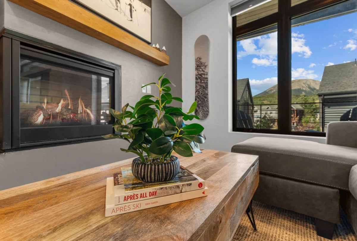 Lit fireplace beside a solid timber table
