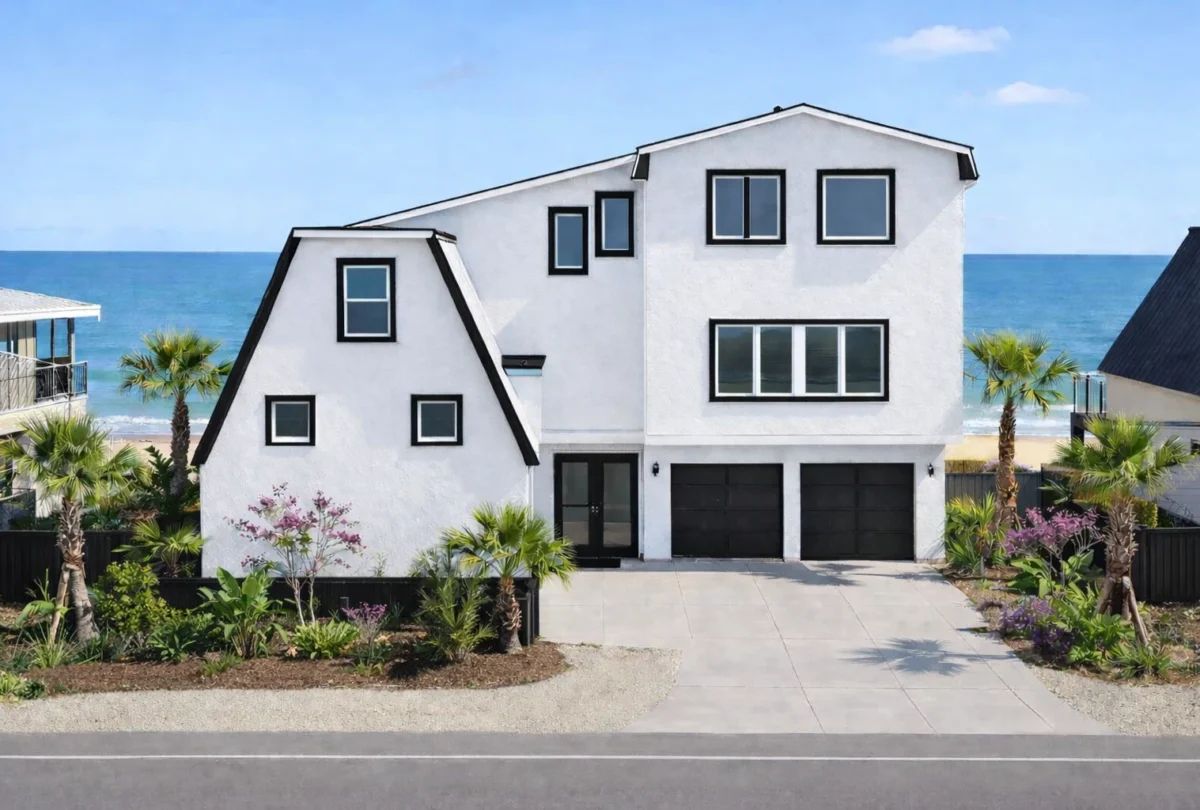 White oceanfront house with black-framed windows and palm trees