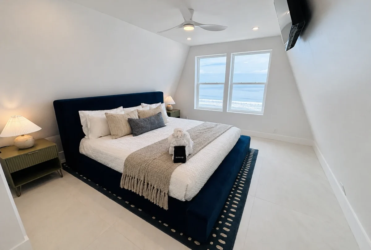 Bedroom with a navy headboard and a striped rug